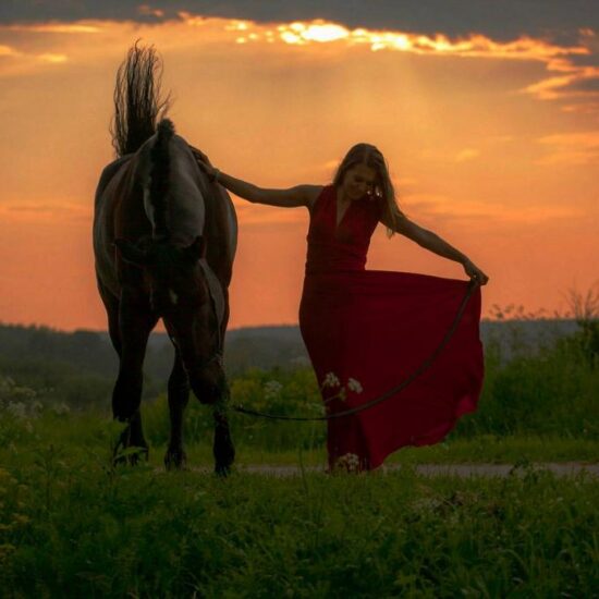 Photo session with a beautiful woman with black horse in the Vesuvius National Park with sunset