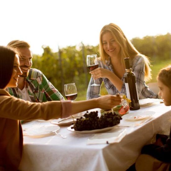 Family enjoy wine in a vineyard in Naples, Italy