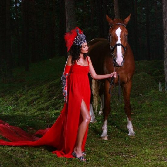 a beautiful woman with brown horse in the wood