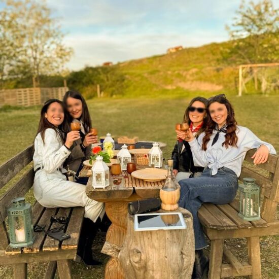 gruppo di ragazze fa un aperitivo allestito con luci e candele, nel parco nazionale del Vesuvio