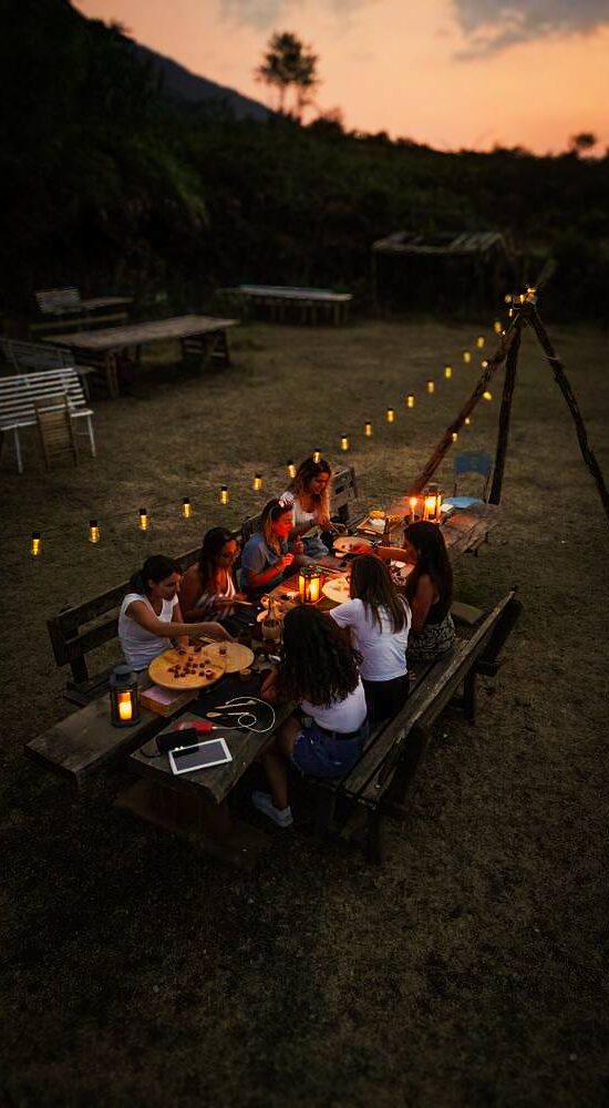 gruppo di ragazze a lume di candela che fanno un aperitivo ai piedi del Vesuvio