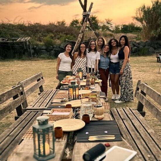 gruppo di ragazze fa un aperitivo allestito con luci e candele, nel parco nazionale del Vesuvio