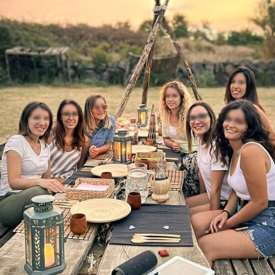 gruppo di ragazze fa un aperitivo allestito con luci e candele, nel parco nazionale del Vesuvio