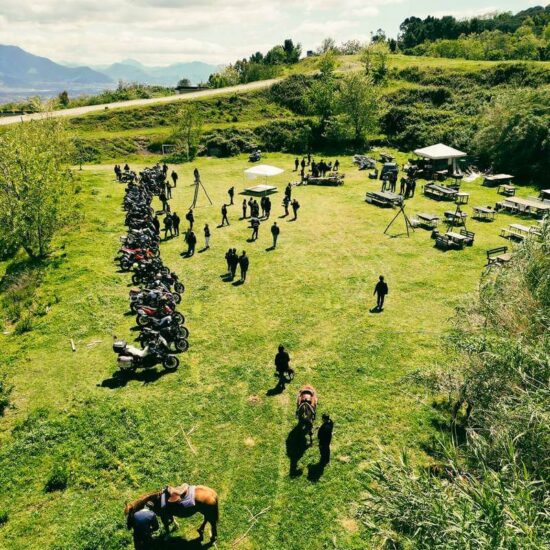 moto parcheggiata su un'area verde con cavalli e persone in festa del Vesuvio