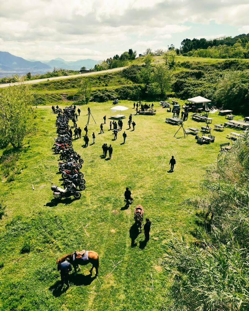 moto parcheggiata su un'area verde con cavalli e persone in festa del Vesuvio