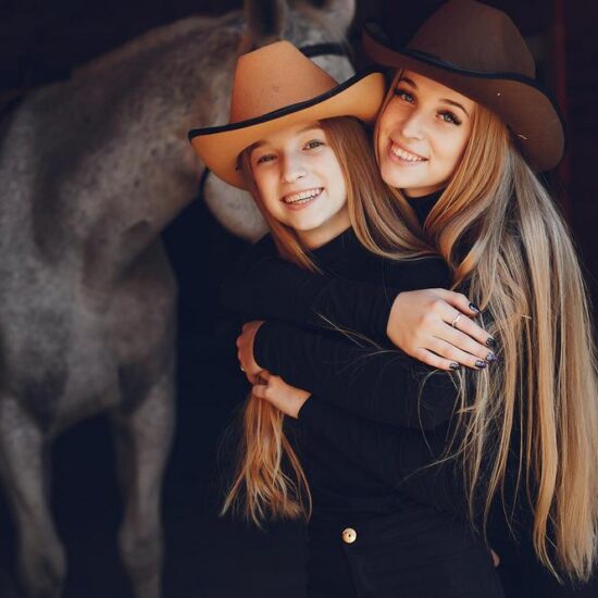 Girls with a horse. Women in a ranch. Blonde in a black sweater. Photo session Naples