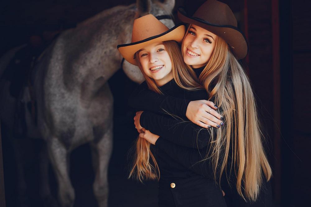 Girls with a horse. Women in a ranch. Blonde in a black sweater. Photo session Naples