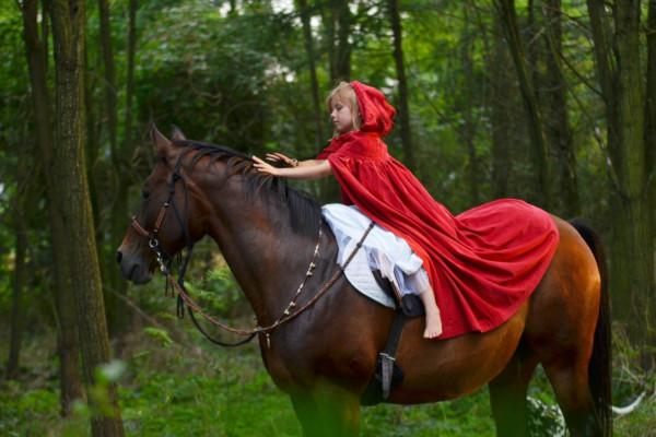 kid in photo session. She is on horseback in the wood